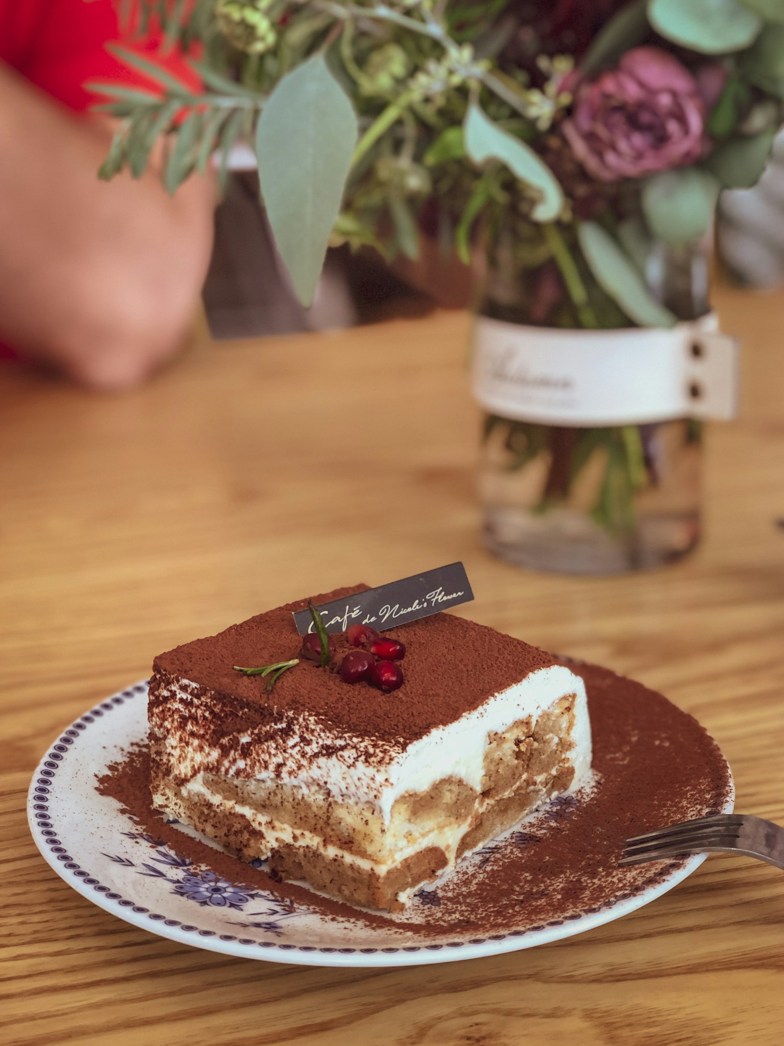 Slice of tiramisu dusted with cocoa powder showing layered cream and ladyfingers