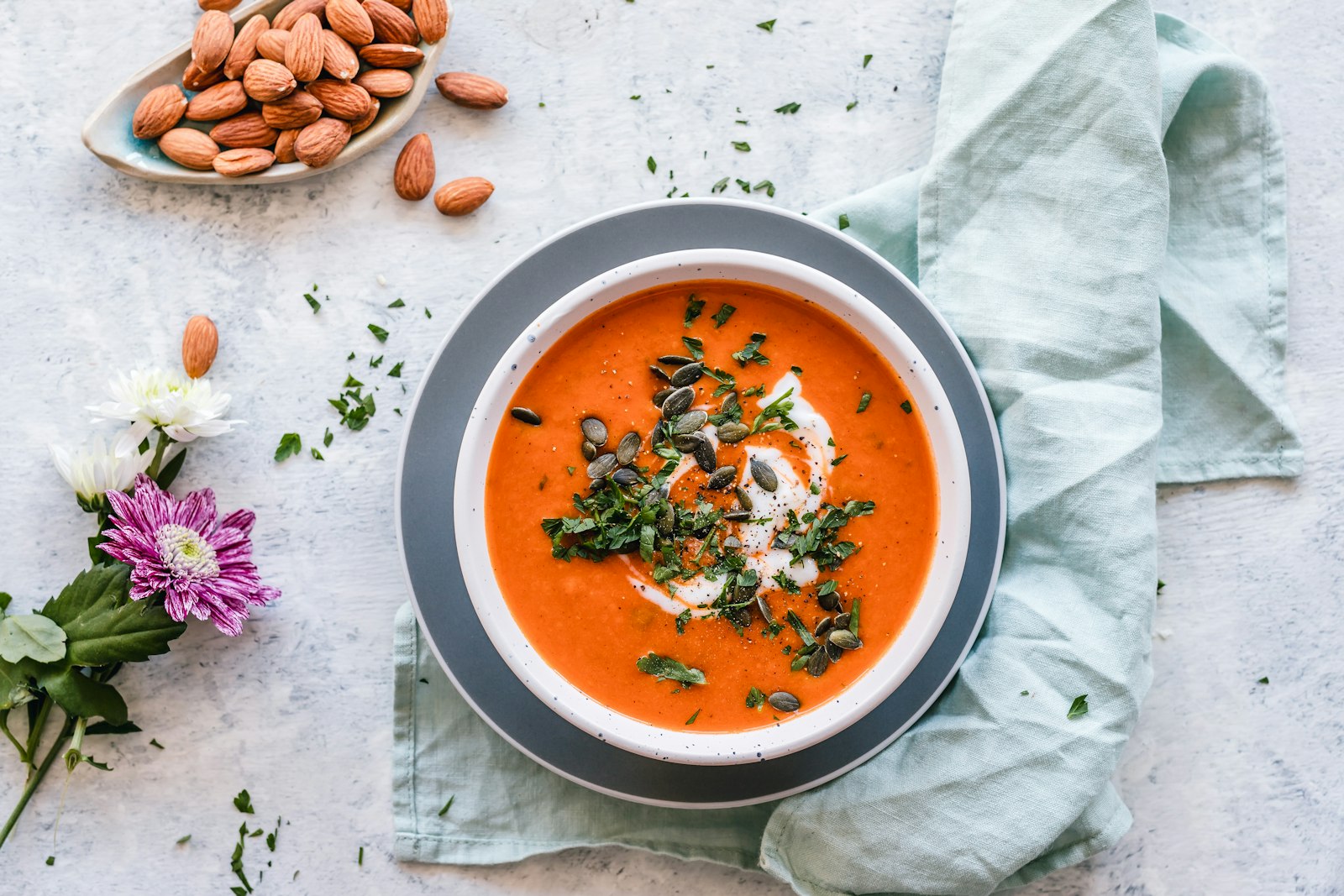 Bowl of creamy tomato basil soup with a drizzle of cream and fresh basil